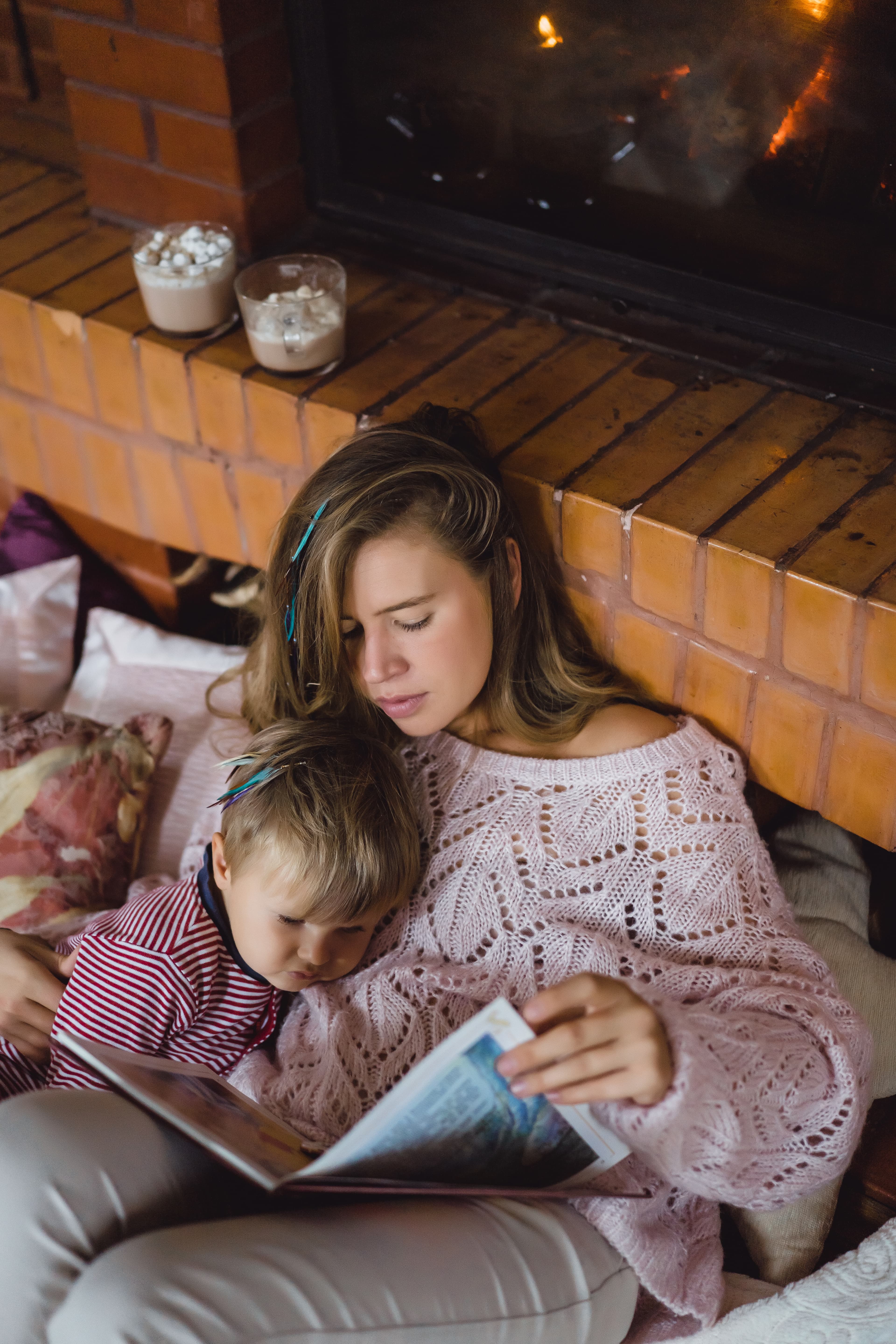 Mother and son reading by the fireplace
